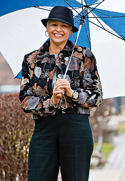 smiling woman in hat holding umbrella